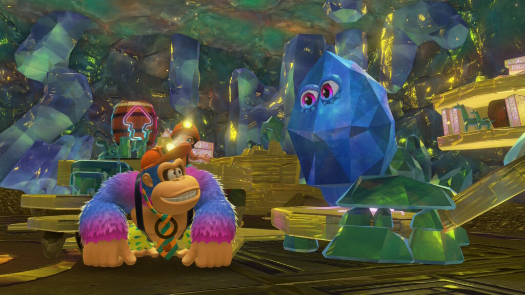 A screen capture of Donkey Kong Bananza. Donkey Kong and Pauline discover the location of the Exploritone, a blue crystal with eyes surrounded by carved tablet.